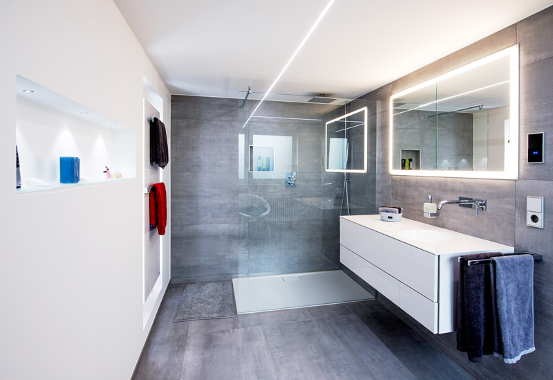 Modernes Badezimmer mit bunten Handtüchern und bodenebener Dusche