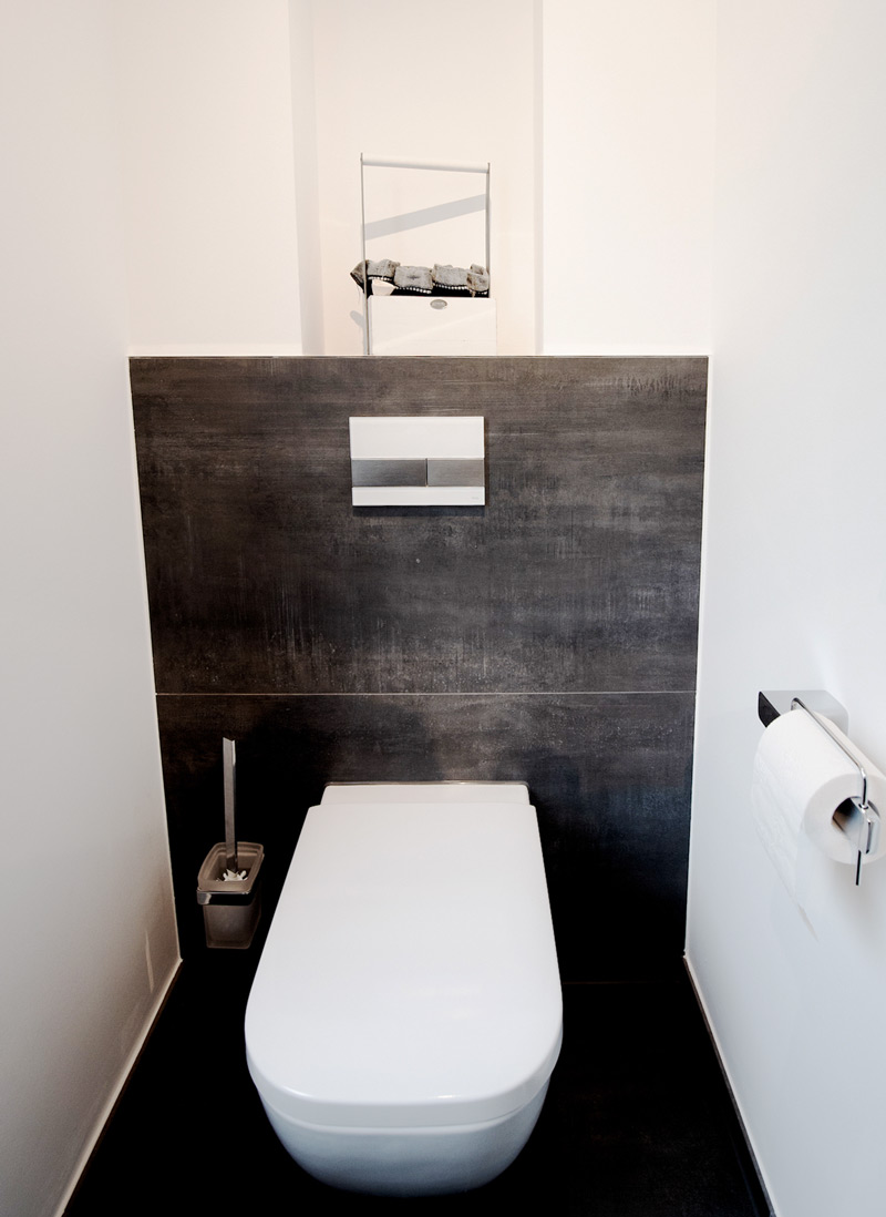 Moderne Gästetoilette in grau mit Toilettenpapierhalterung